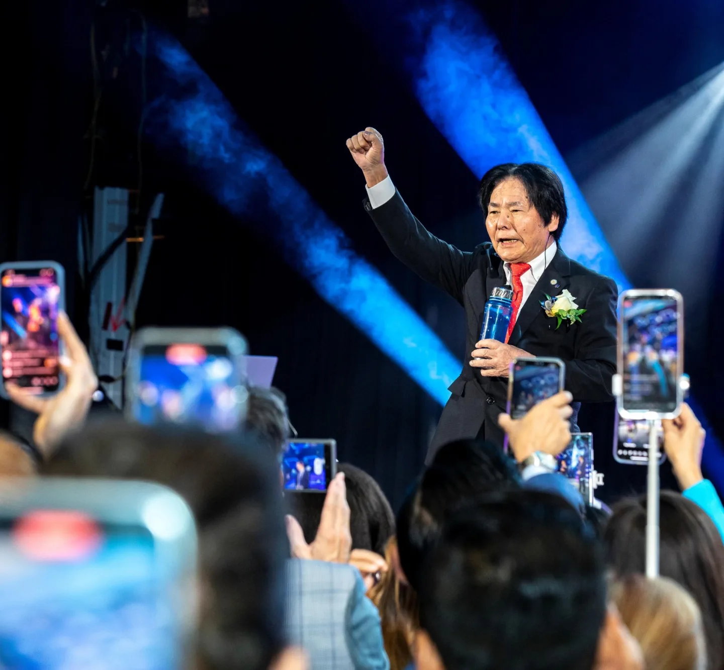 A leader rallies the crowd from the stage